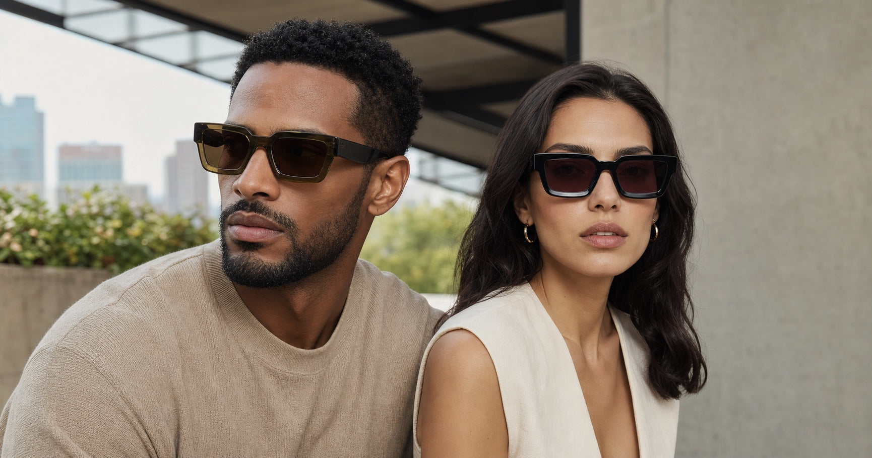 A man and woman wearing The Herald sunglasses in a refined outdoor setting